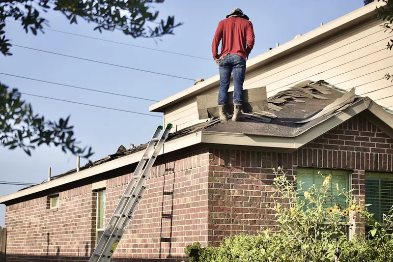 Professional roofer working on a residential roof in Elba